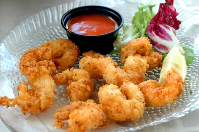 popcorn shrimp on a plate with hot sauce