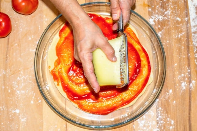 cooking pizza, sauce, grating cheese