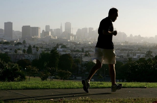 SAN FRANCISCO - JULY 13: With the San Francisco skyline in the background, a jogger runs through Dolores Park July 13, 2005 in San Francisco. Runner's World Magazine has just named San Francisco the best city for running in the United States based on its weather, the number of running clubs, racing events and the the ample park space available for runners. (Photo by Justin Sullivan/Getty Images)