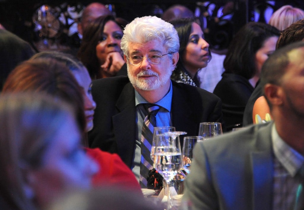 George Lucas at a press dinner, wearing a suit and smiling George Lucas at a press dinner, wearing a suit and smiling
