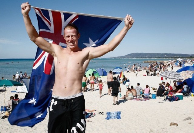 RYE, AUSTRALIA - JANUARY 26: A young man holds the Australian flag above his head during Australia Day celebrations January 26, 2007 in Rye, Australia. Australians all over the country and abroad are celebrating Australia Day. (Photo by Simon Fergusson/Getty Images)