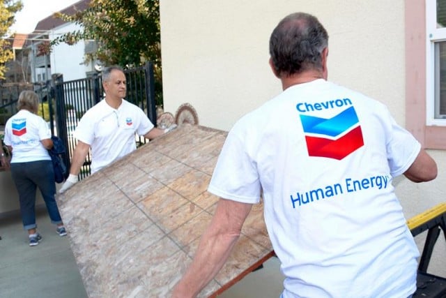 Chevron employees with the company logo on their shirts volunteering.