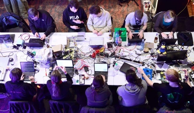 Participants work at their laptops at the annual Chaos Computer Club (CCC) computer hackers' congress, called 29C3, on December 28, 2012 in Hamburg, Germany. The 29th Chaos Communication Congress (29C3) attracts hundreds of participants worldwide annually to engage in workshops and lectures discussing the role of technology in society and its future. (Photo by Patrick Lux/Getty Images)