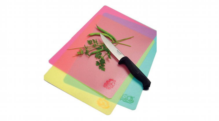 Three plastic cutting boards, a knife, and herbs
