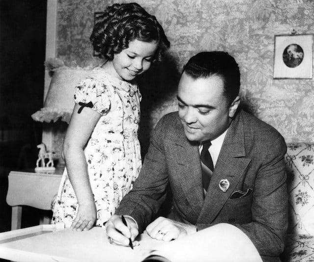 John Edgar Hoover, signing young actress Shirley Temple's autograph books