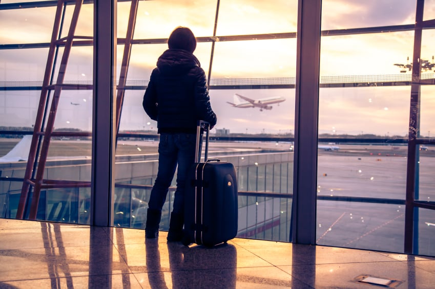 a woman looking out the window with luggage