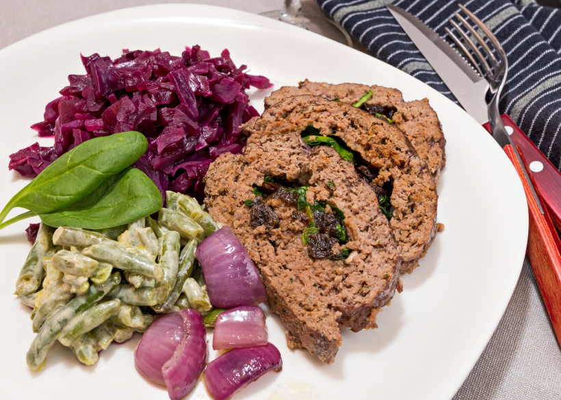 Meatloaf stuffed with spinach and a side dish of red cabbage and green beans