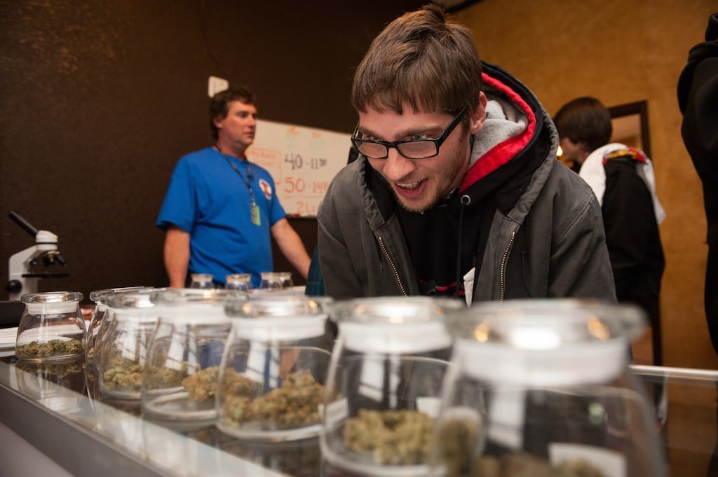 Tyler Williams of Blanchester, Ohio selects marijuana strains to purchase at the 3-D Denver Discrete Dispensary on January 1, 2014 in Denver, Colorado. Legalization of recreational marijuana sales in the state went into effect at 8am this morning. (Photo by Theo Stroomer/Getty Images)