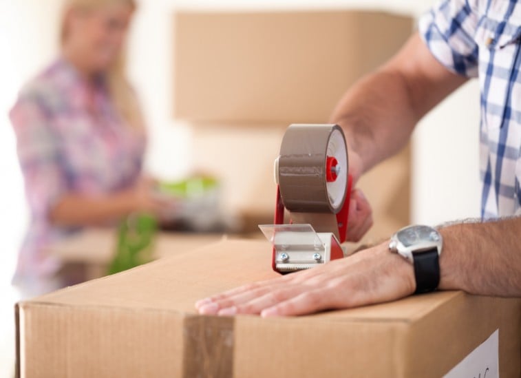 A couple packs boxes of their belongings as they get ready to move