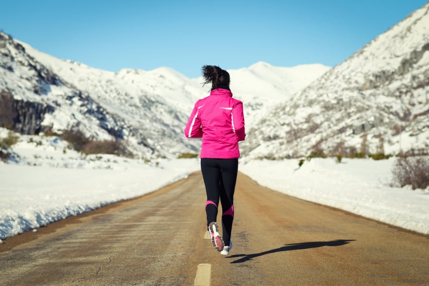 Woman running on a road in the winter