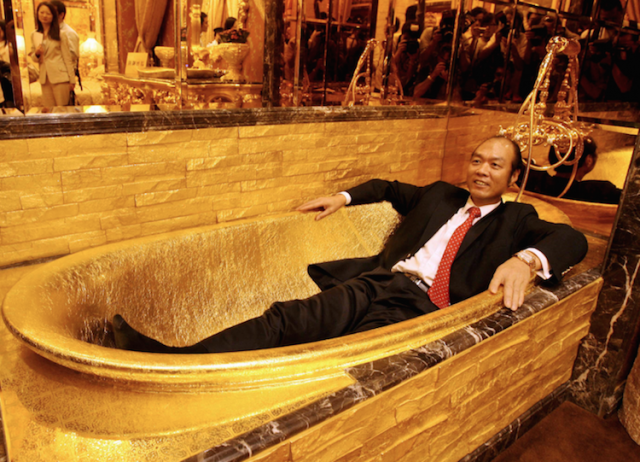 A man sits in a golden bath tub