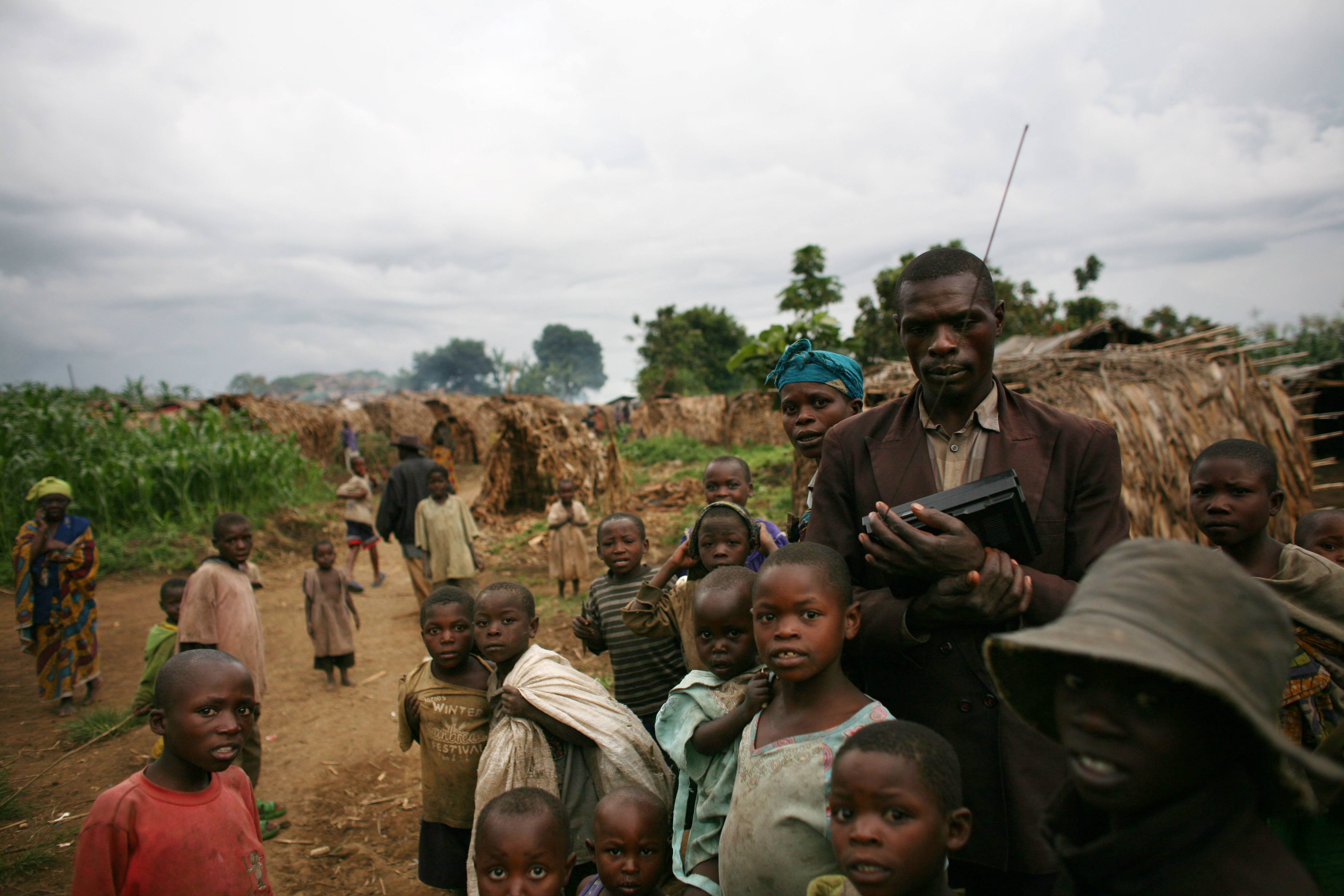 Refugees wait near their shelters in the Democratic Republic of the Congo