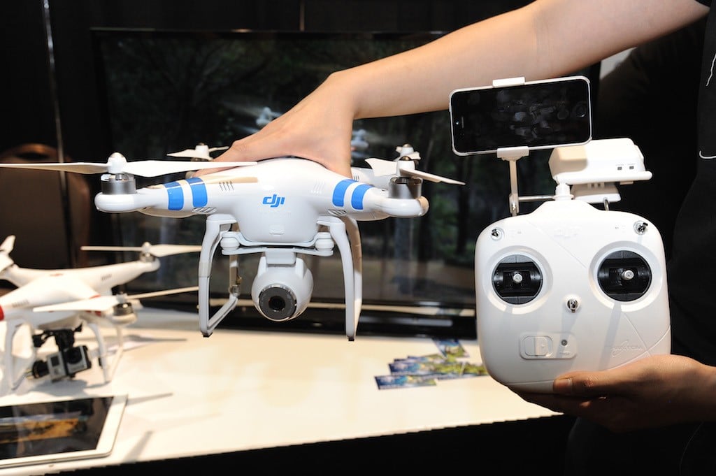 A DJI Innovations DJI Phantom 2 Vision aerial system drone with controller (R) is shown during 'CES: Unveiled,' the media preview for International CES, at the Mandalay Bay Convention Center January 5, 2014 in Las Vegas, Nevada. The Phantom 2 Vision, available for USD 1,199, has a 14-megapixel camera on board that can shoot raw photos and 1080p video. The video can be seen live and stored on an iPhone or Android smart phone attached to the controller. (Photo by Robyn Beck/AFP/Getty Images)