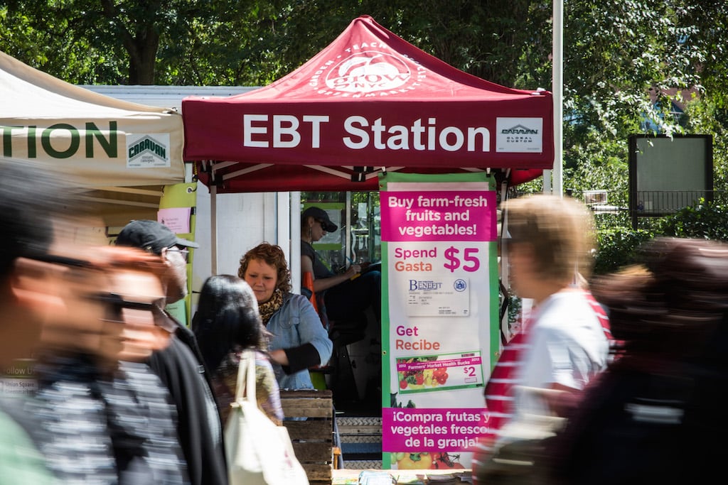 People walk past an Electronic Benefits Transfer (EBT) station, more commonly known as Food Stamps, in the GrowNYC Greenmarket in Union Square on September 18, 2013 in New York City. According to a Gallup poll released earlier this month, 20% of American adults struggled to buy enough food at some point in the last year. The rate of hungry people in America has gone relatively unchanged since 2008, suggesting the economic recovery since the 2008 recession may be disproportionately affecting the wealthy. More than 50 of GrowNYC's Greenmarket's now accept EBT; over $800,000 in sales were complete with EBT payment at the Greenmarket's in 2012. GrowNYC is also currently offering a program known as Health Bucks: for ever $5 spent using EBT at a Greenmarket, GrowNYC provides an additional $2, which can be spent specifically on fresh fruits and vegetables. (Photo by Andrew Burton/Getty Images)