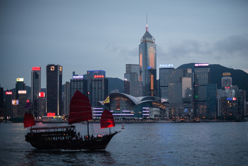 A junk sails on Victoria Harbour in front of the city's skyline in Hong Kong on June 3, 2013. The harbour waters is mostly crowded and often see high-speed hydrofoils vying for space with tourist junks, luxury yachts and a century-old public ferry system that connect Hong Kong island to the Kowloon peninsula. Photo by Philippe Lopez/AFP/Getty Images.