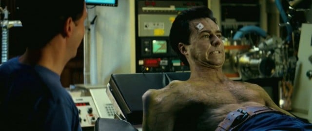 Edward Norton lays on a bed and grimaces in The Incredible Hulk