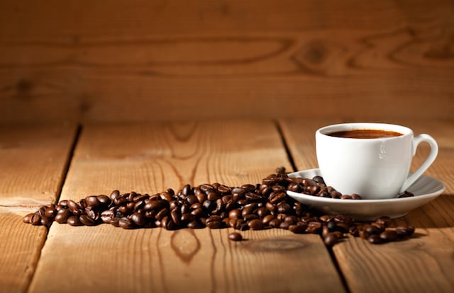 coffee mug surrounded by beans on a table