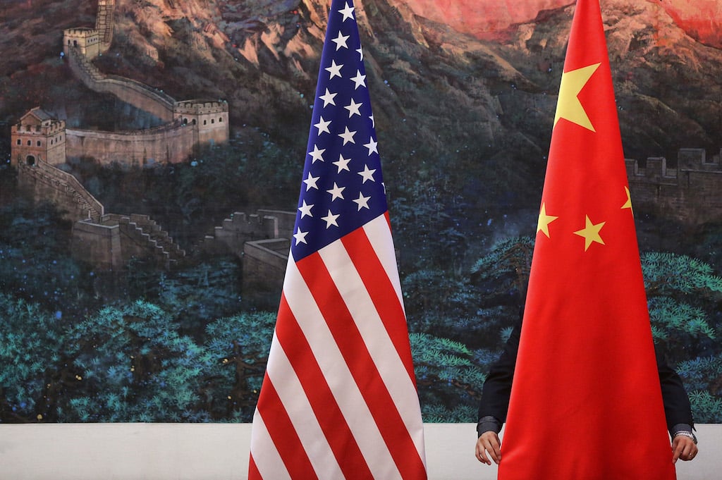 A Chinese man adjusts a Chinese flag before Chinese Foreign Minister Yang Jiechi and US Secretary of State Hillary Clinton's press conference at the Great Hall of the People in Beijing on September 5, 2012. (Photo by Feng Li/Getty Images)