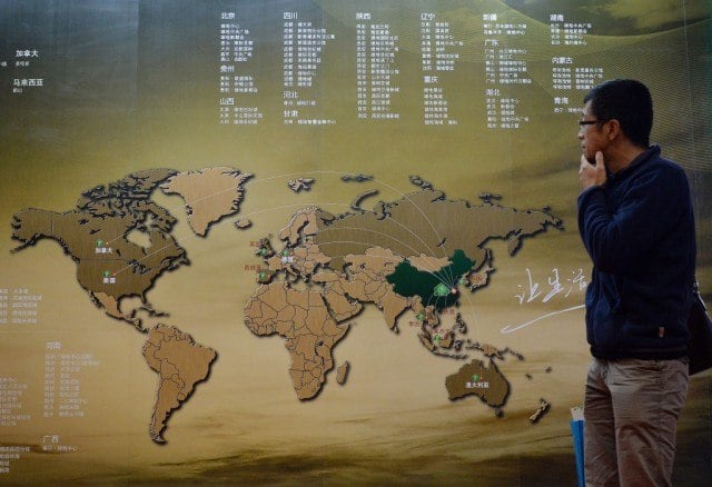 A Chinese investor walks past an investment map showing suitable property markets for wealthy Chinese to invest in at the International Property Expo in Beijing on April 11, 2014. Wealthy Chinese will pour AUD$44 billion (US$39.4 billion) into Australian real estate over the next seven years, potentially pushing prices in one of the world's most expensive housing markets even higher. Chinese property investors have been on a international spending spree since the global financial crisis hit most of the world's economies. Photo by Mark Ralston/AFP/Getty Images
