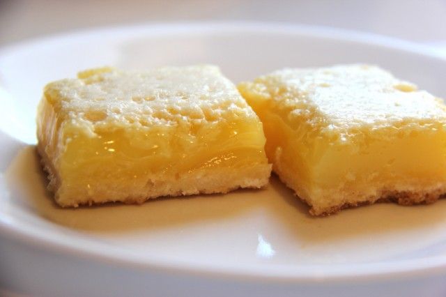 homemade lemon bars dusted with powdered sugar on a plate