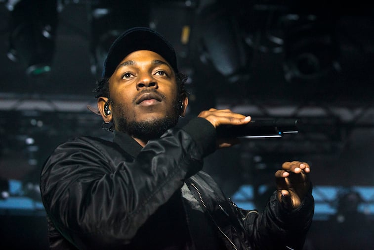 Kendrick Lamar holds a microphone on stage