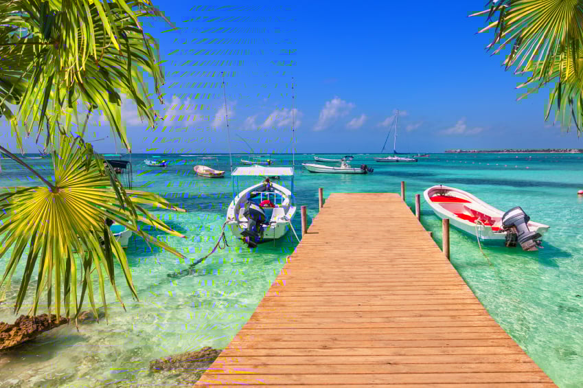 wooden pier and fishing boats on a Caribbean beach with transparent waters, beach