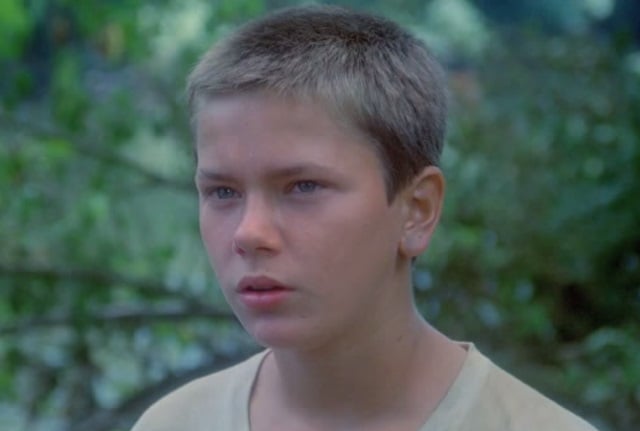 River Phoenix looks to his right in Stand By Me in the woods