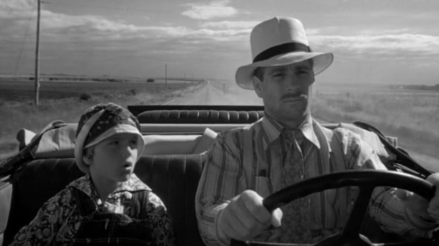 A young Tatum O’Neal sits in the passenger seat next to Ryan O'Neal in Paper Moon