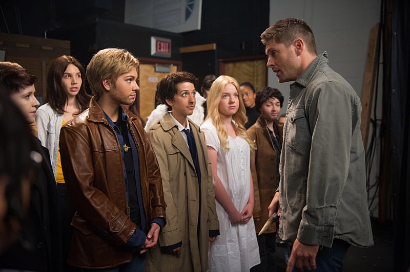 A young girl dressed up like Jensen Ackles, standing on stage with him and a group of other children