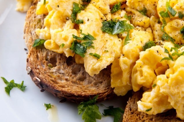 close image of scrambled eggs on toast with herbs close image of scrambled eggs on toast with herbs