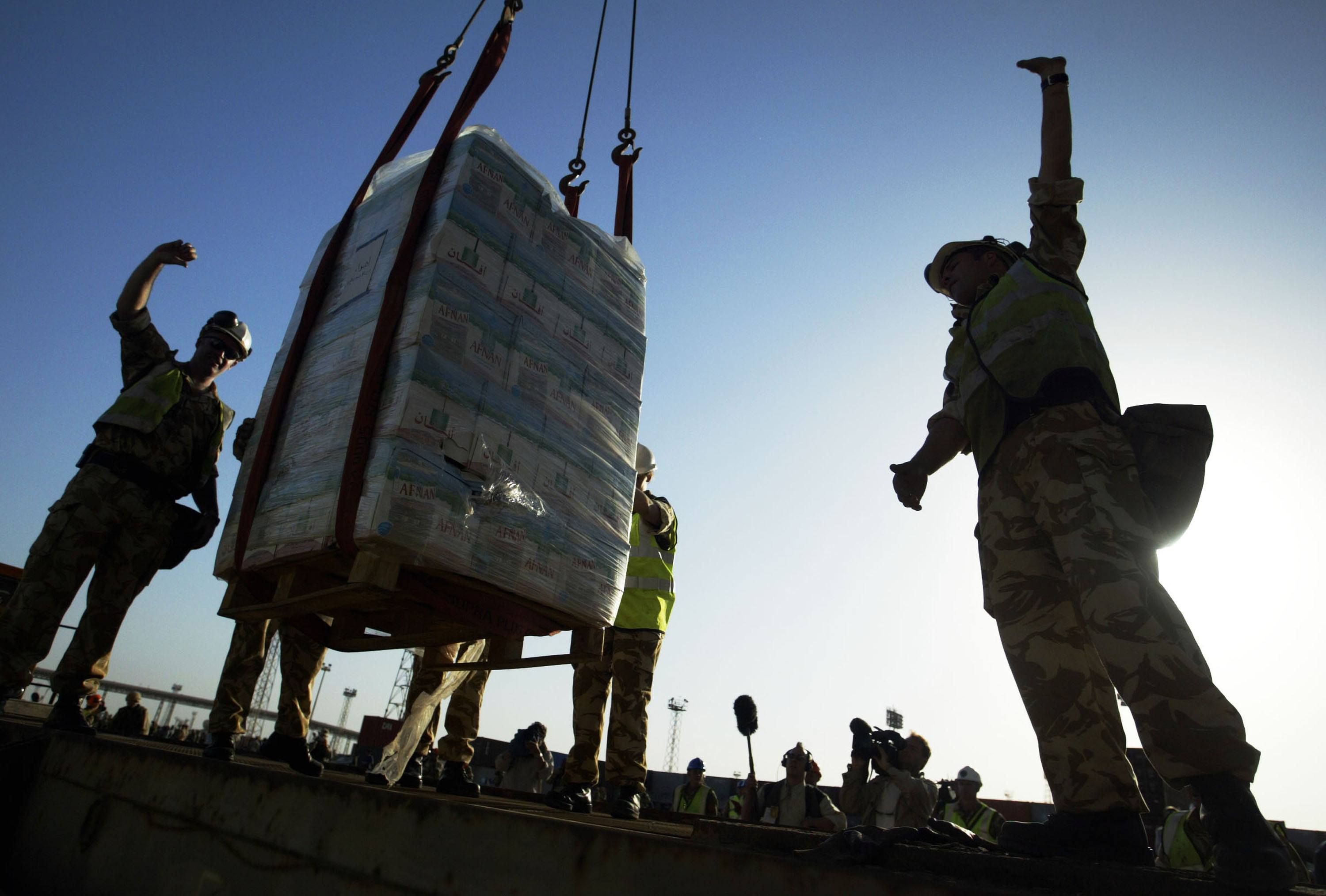 A pallet of fresh bottled water is lowered onto a dock in Iraq