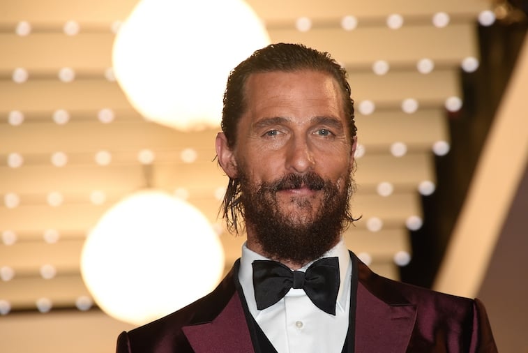 Matthew McConaughey smiling in front of lights wearing a black bowtie