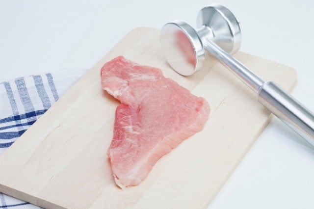 Raw turkey cutlet and meat tenderizer
