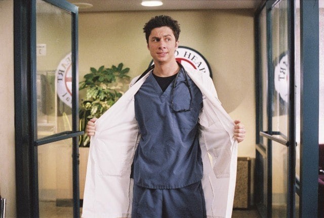J.D. walking into Sacred Heart Hospital in scrubs and a white jacket, which he is holding open. J.D. walking into Sacred Heart Hospital in scrubs and a white jacket, which he is holding open.