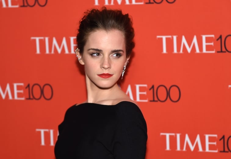 Emma Watson poses in a black dress on the red carpet.