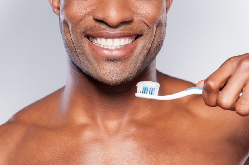 man smiling with his toothbrush