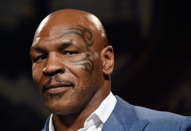 Mike Tyson in a suit looking towards his side. Mike Tyson in a suit looking towards his side.