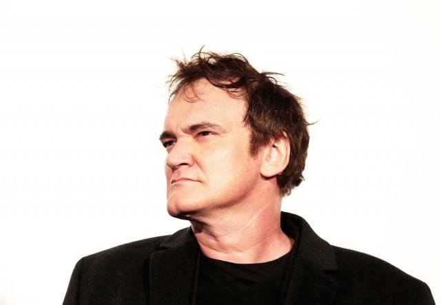 Quentin Tarantino wearing a black jacket and shirt in front of a white background. Quentin Tarantino wearing a black jacket and shirt in front of a white background.