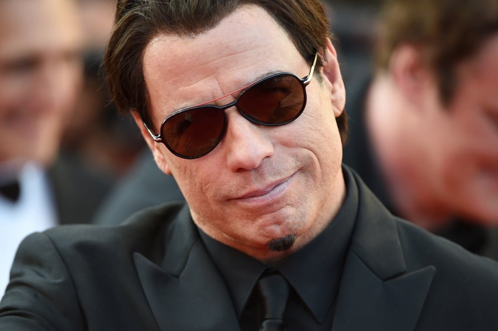 John Travolta wearing sunglasses and a black suit