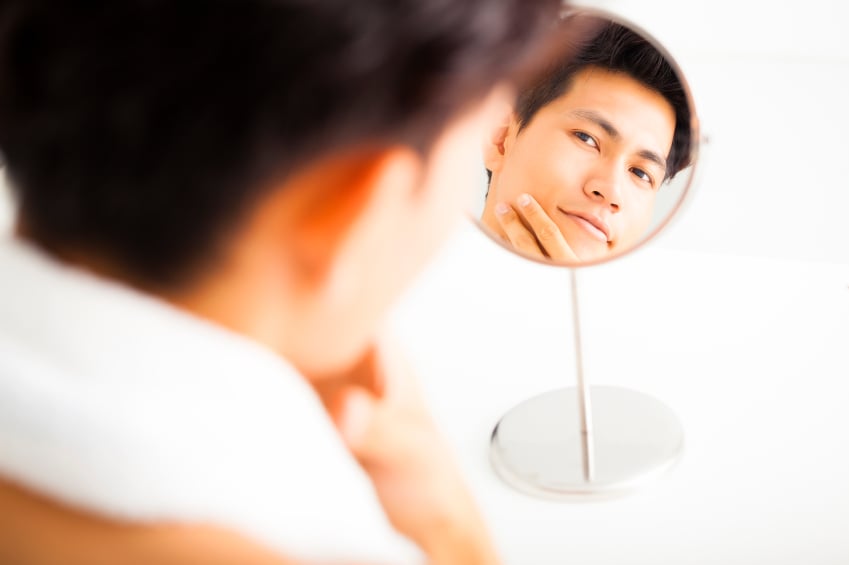 Clean shaven man looking in the mirror
