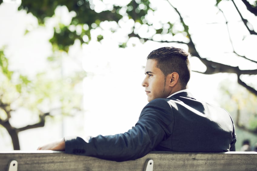 a handsome man sitting on a bench