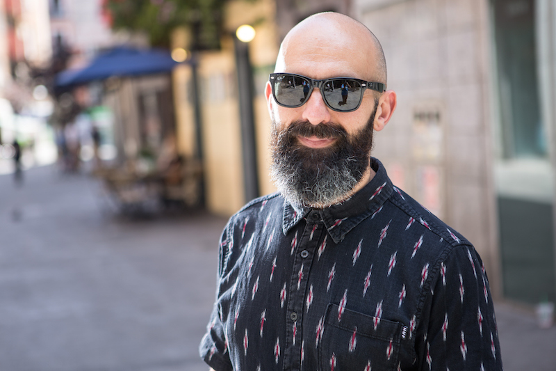 a trendy man wearing a button up shirt and sunglasses