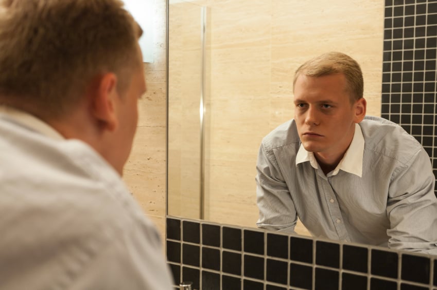 a sick man looking in the mirror