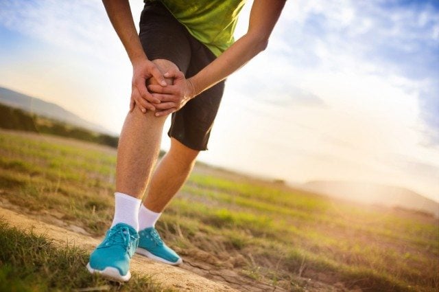 man holding knee while running man holding knee while running