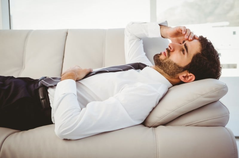 Man feeling sick on the couch Man feeling sick on the couch