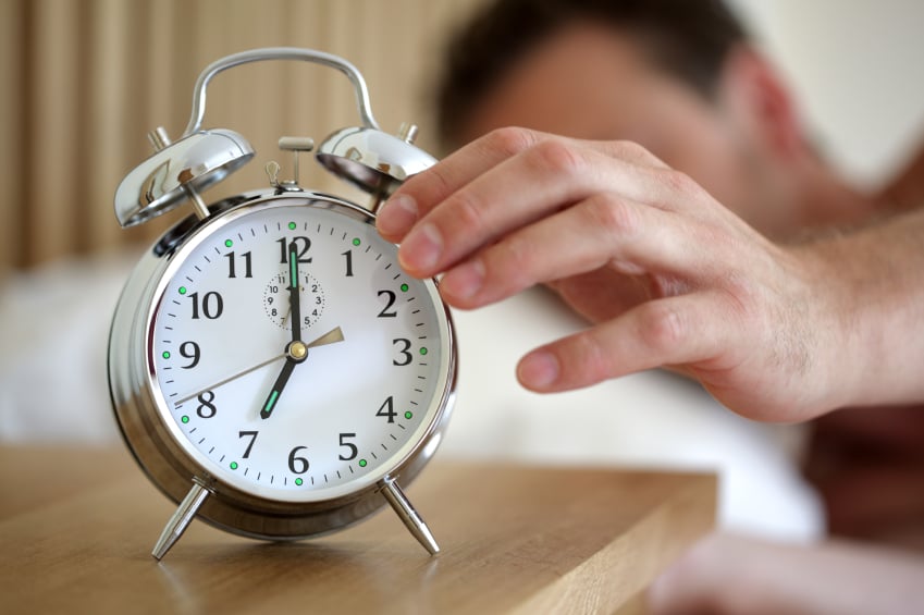 man hitting alarm clock