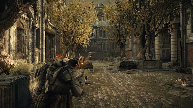 A cog paces down a battered street, gun in hand.