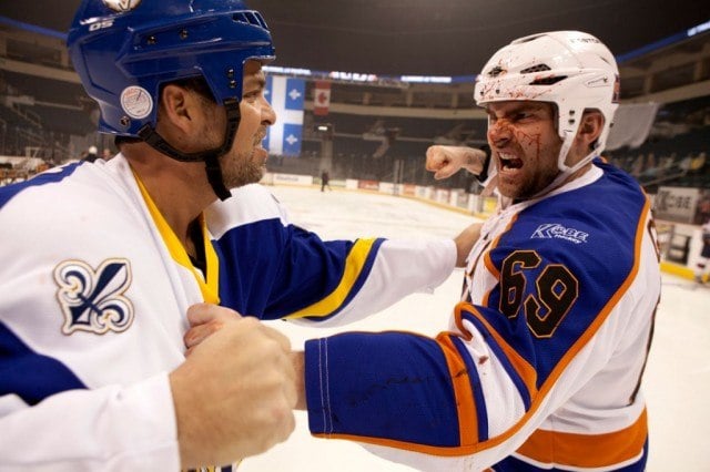 Seann William Scott in a hockey uniform about to punch another player