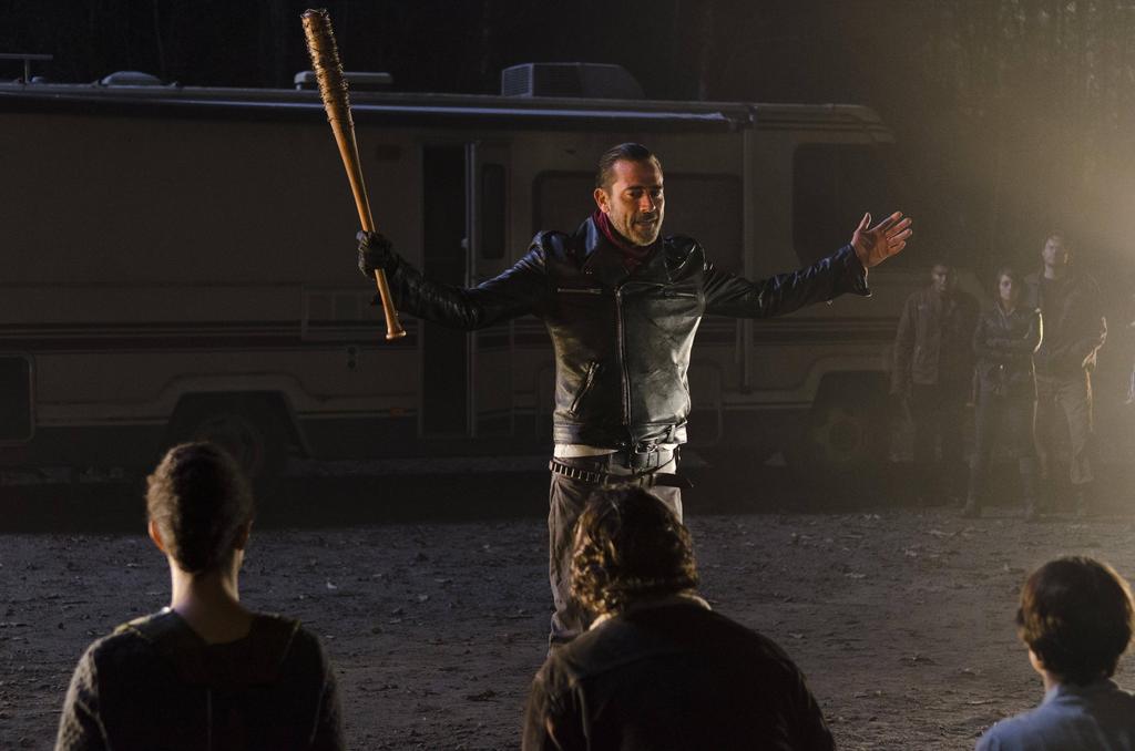 Negan with his arms out, holding his barbed-wire baseball bat in his right hand