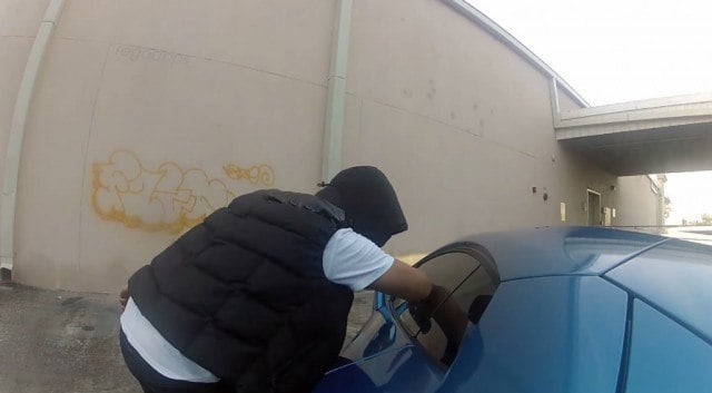 A man is attempting to rob a parked car